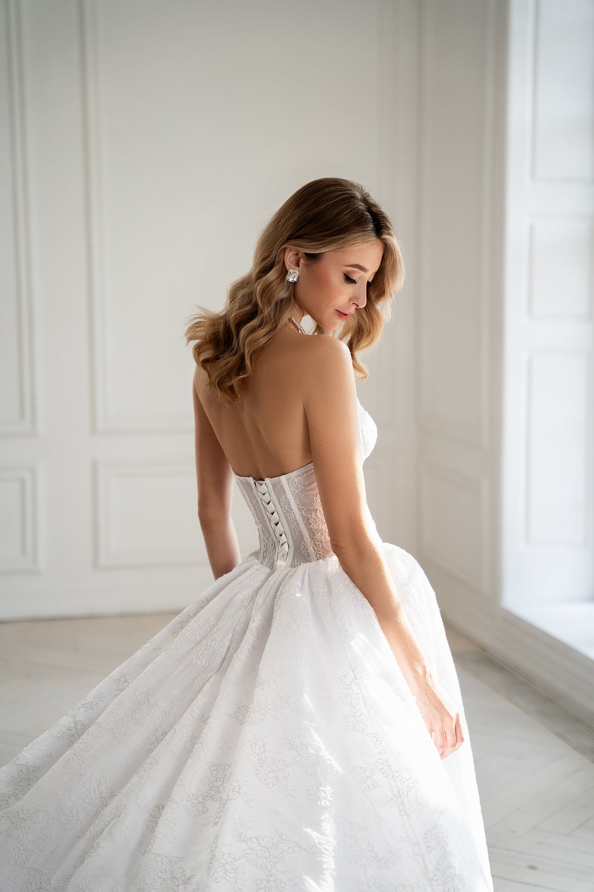 Lace-up corset back detail on strapless wedding dress with train