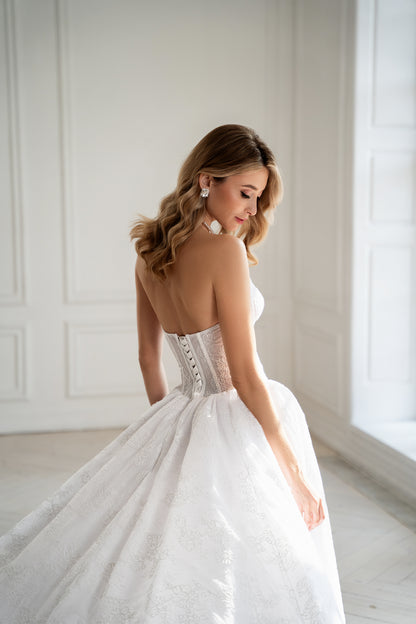 Lace-up corset back detail on strapless wedding dress with train
