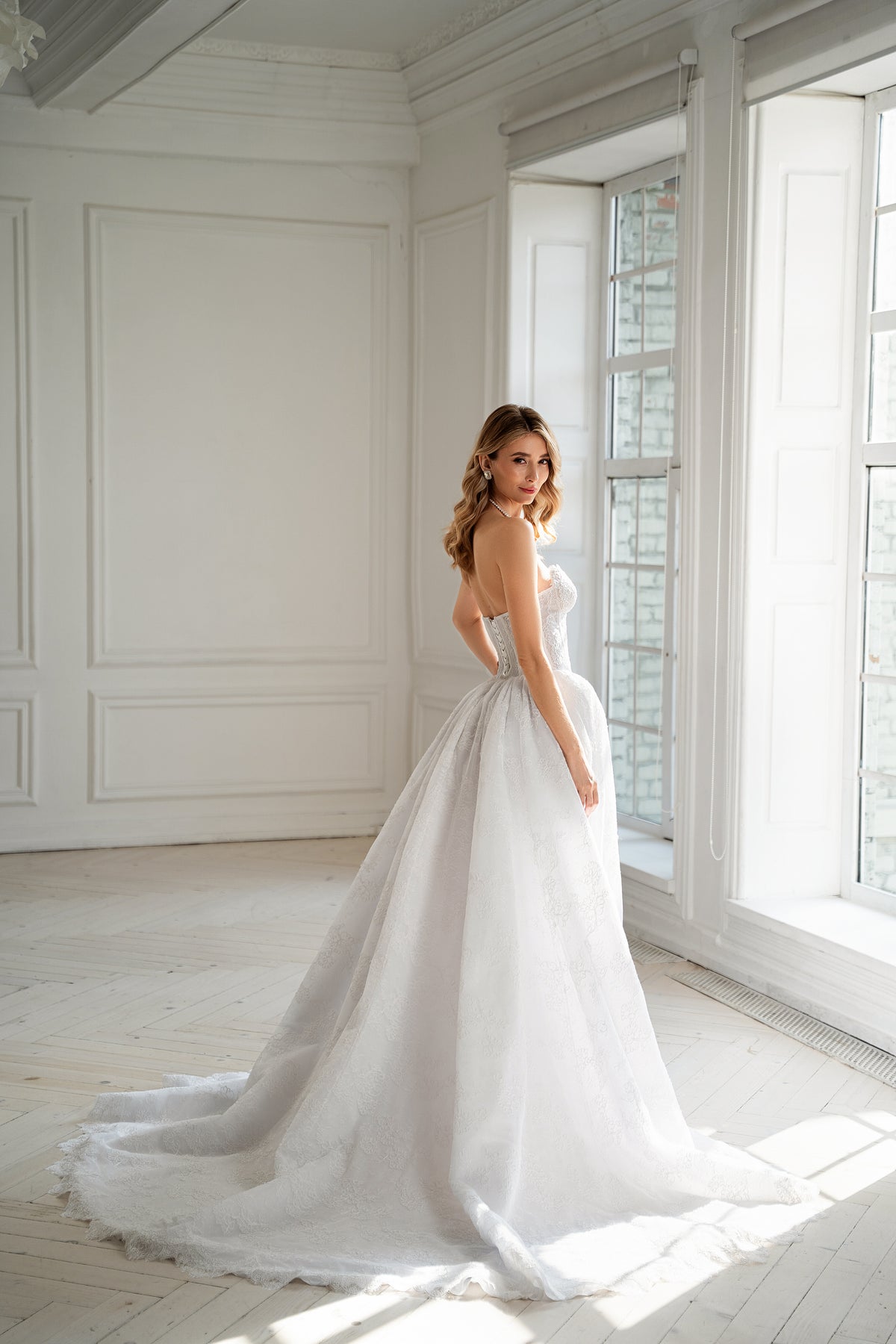 Lace-up corset back detail on strapless wedding dress with train