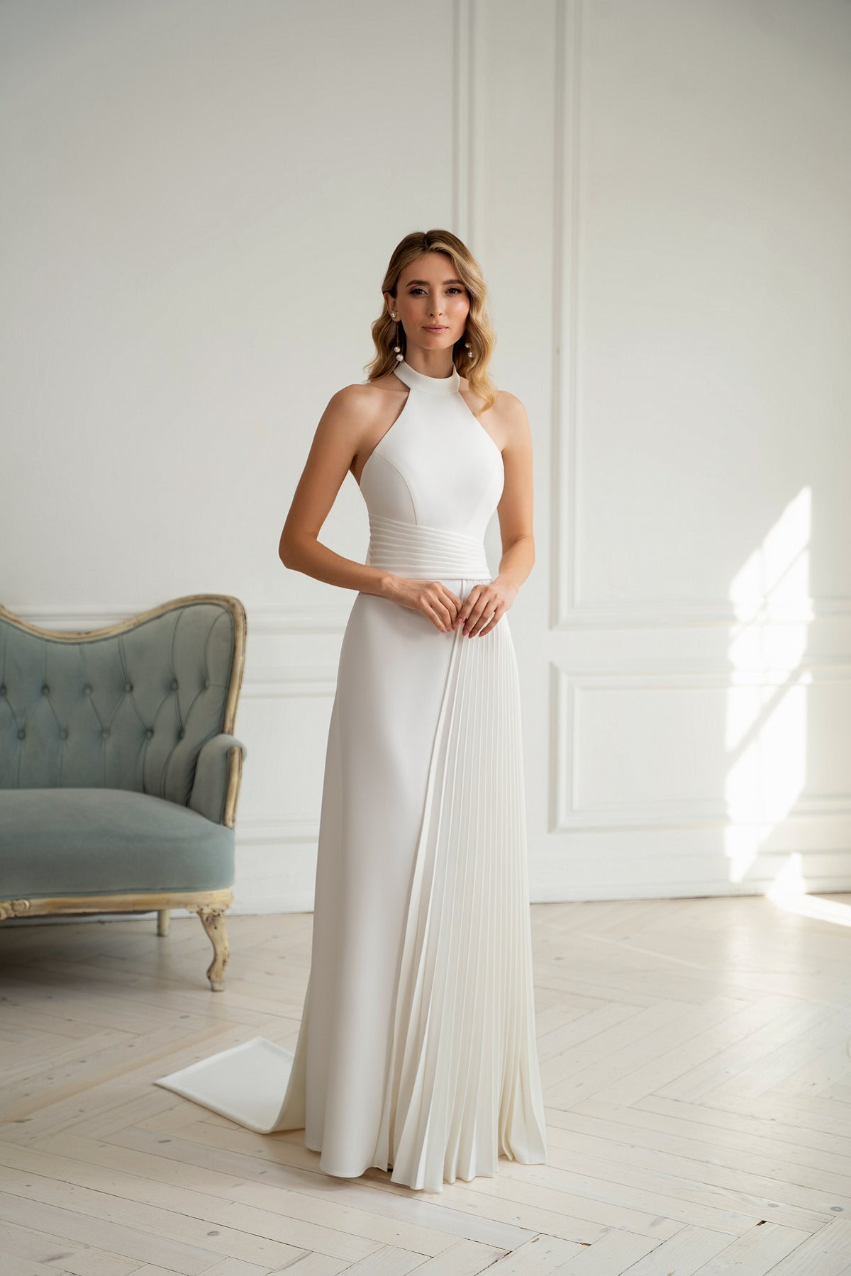 "Bride wearing minimalist halter neck wedding dress with pleated waist"

