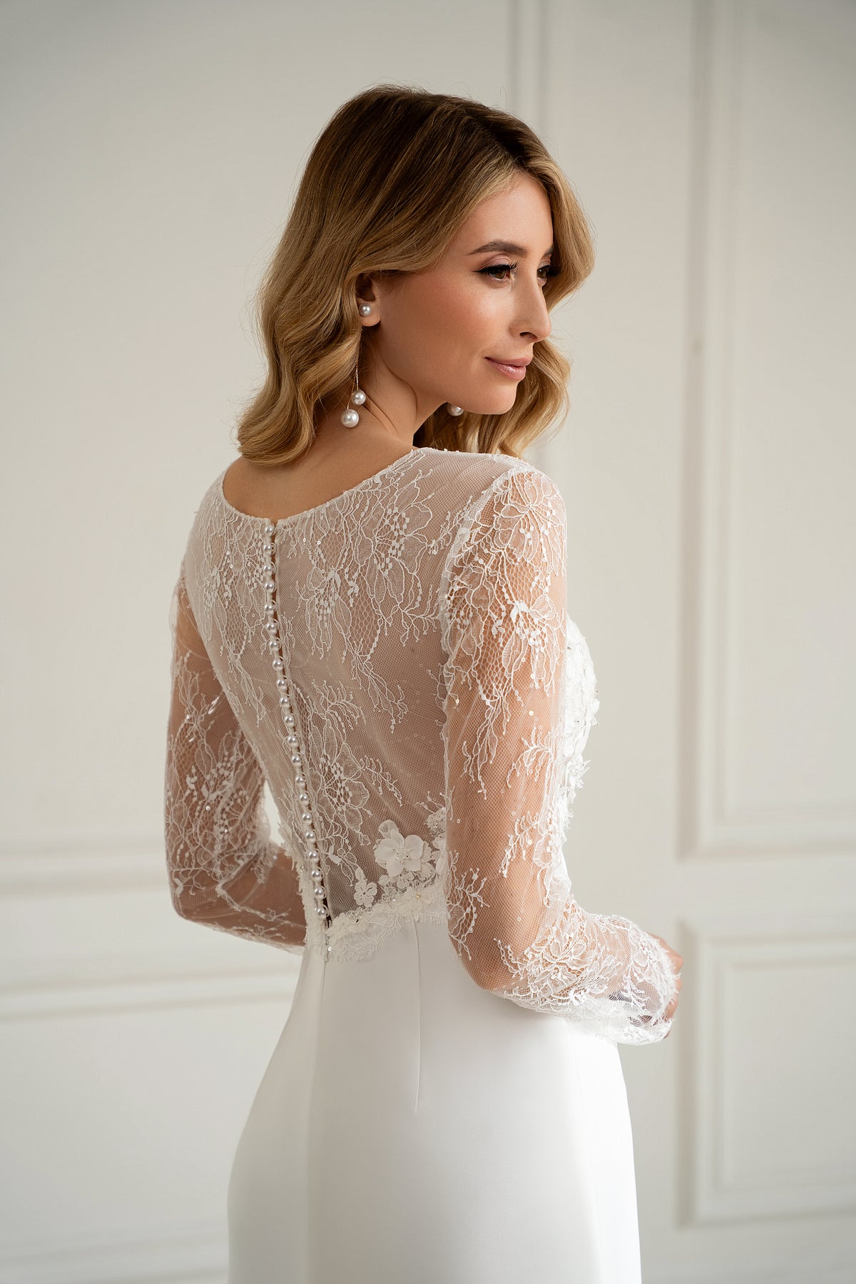 "Bride in long sleeve lace wedding dress with 3D floral bodice, front view"